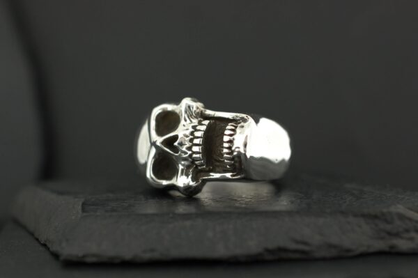 Silver skull ring with intricate detailing.