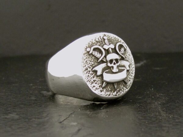 Silver ring with a playful cartoon face engraving.