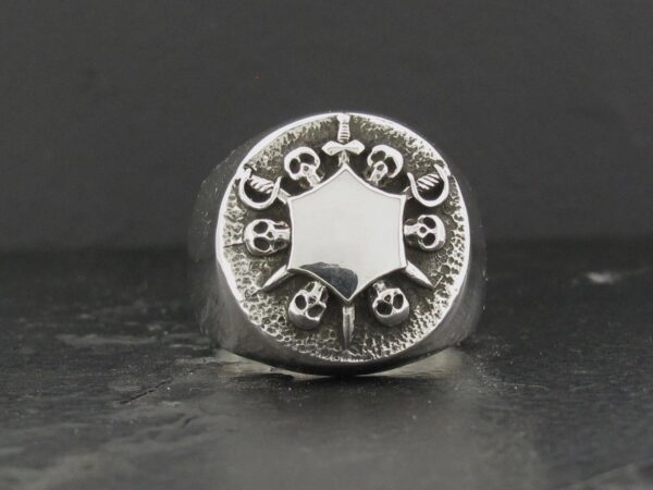 Intricately designed silver ring with gothic skull motifs.