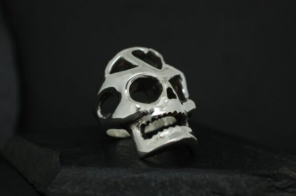 A metallic skull sculpture with hollow eyes and detailed teeth.