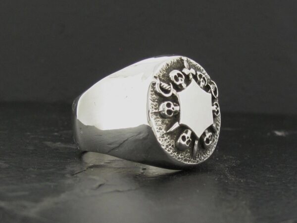 Silver ring with a star-shaped design and engraved text.