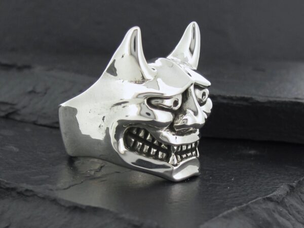A silver metallic ring shaped like a menacing Oni mask.