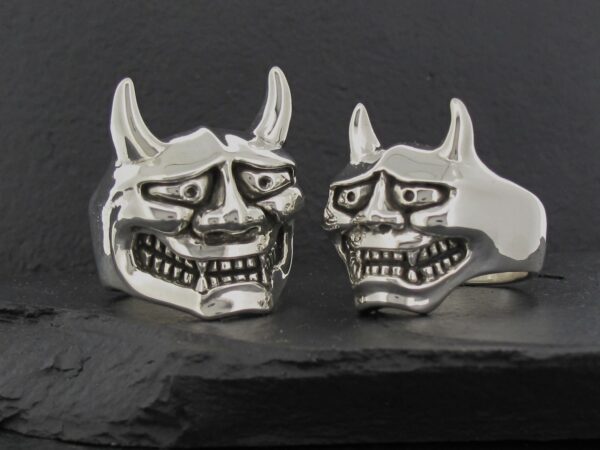 Two silver rings shaped like menacing demon faces.
