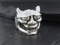 Silver ring shaped like a menacing demon mask with detailed facial features.