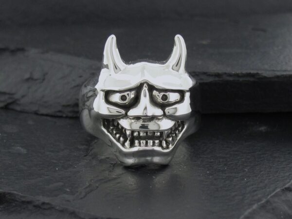Silver ring shaped like a horned demon face with glasses.
