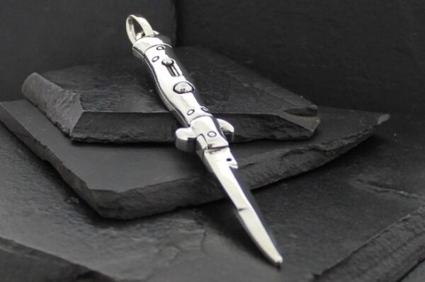 Elegant silver dagger with intricate designs on a dark textured background.