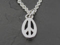 A silver peace symbol pendant on a chain.