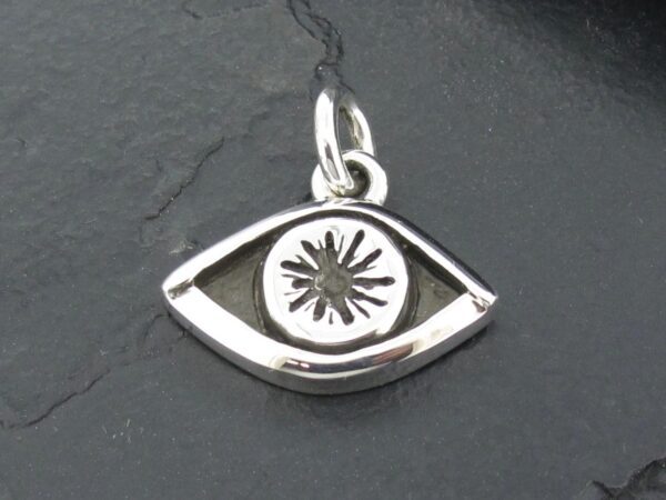 Silver eye-shaped pendant with a starburst design in the center.