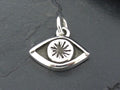 Silver eye-shaped pendant with a starburst design in the center.