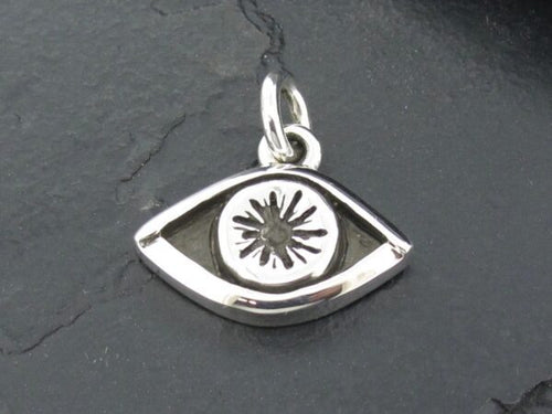 Silver eye-shaped pendant with a starburst design in the center.