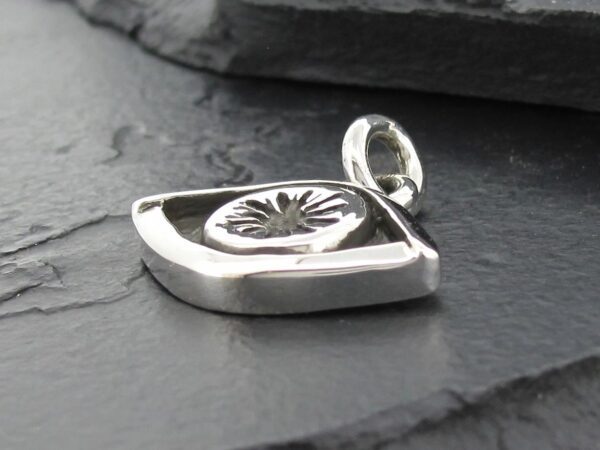 Close-up of a silver locket pendant with a sun design.