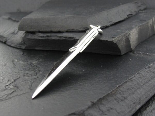Elegant silver pen on dark slate background.
