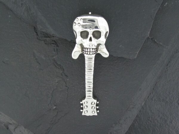 A skull with a guitar neck extending downward on a dark background.