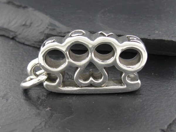 Silver knuckle duster pendant with a heart design.