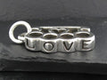Silver charm with the word 'LOVE' engraved on it.