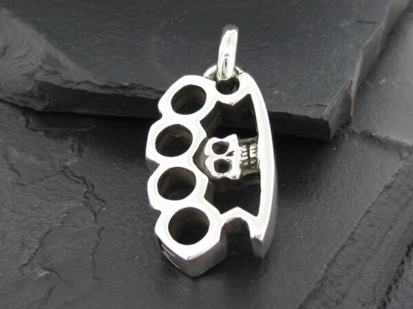 Silver brass knuckles pendant with detailed finger holes and a small crown design.