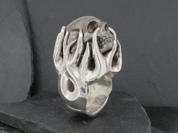 Silver ring designed with a unique skull and flame motif.