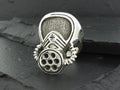 Metal ring with a gas mask design and intricate details.