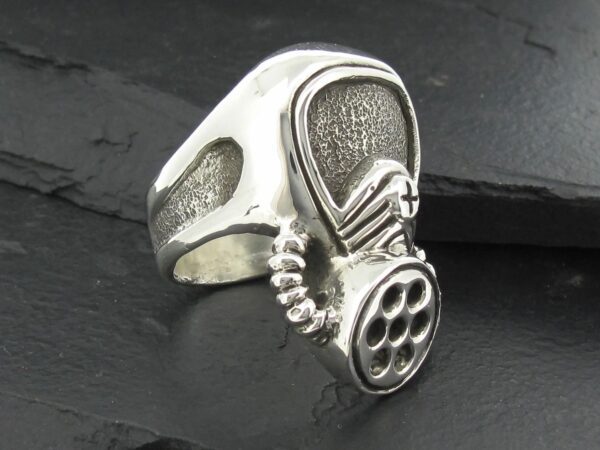A silver ring designed like a gas mask.