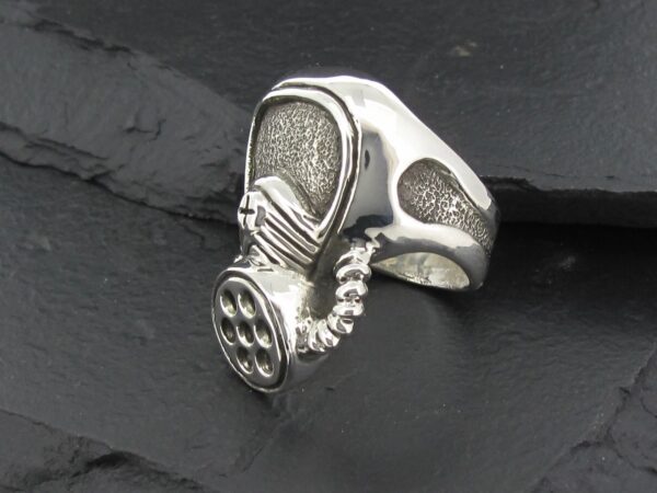 A silver ring shaped like a gas mask with intricate details.