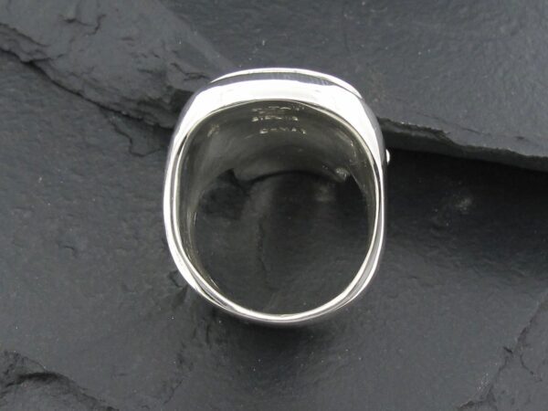 A polished silver ring with a flat, reflective top surface.