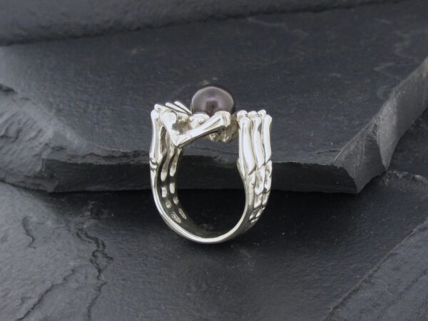 Silver ring with intricate, organic design resembling branches or roots.