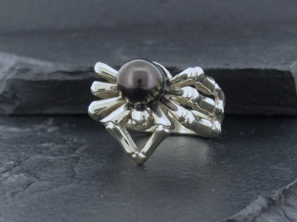 Elegant silver ring with a black pearl centerpiece.
