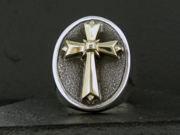 Silver ring with a raised cross design on a textured oval background.