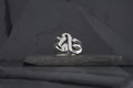 Silver ring with a gothic-style letter design on a dark surface.