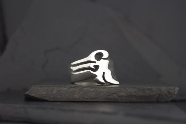 A silver ring with a minimalist human figure design.