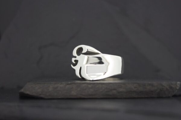 A sleek silver ring with a modern, abstract design.