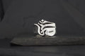 A silver ring with an abstract, artistic design on a dark background.