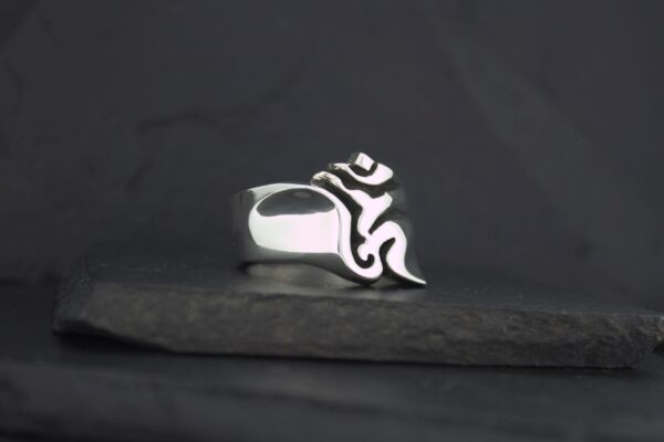 A silver ring with a black tribal flame design.