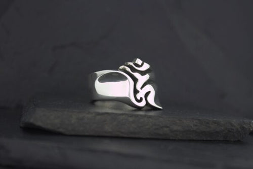A silver ring with a black tribal flame design.