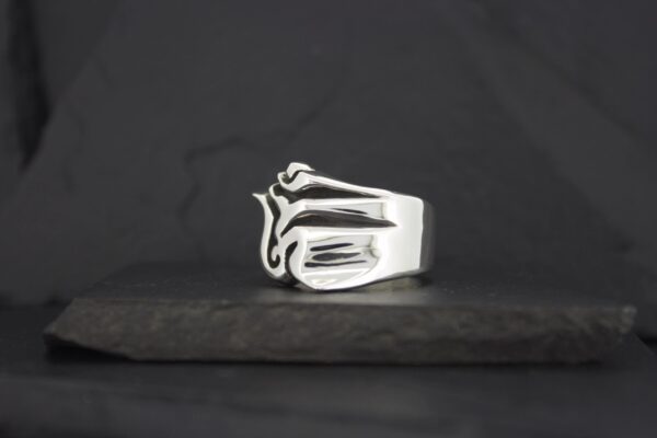 A silver ring shaped like a hand making a gesture.