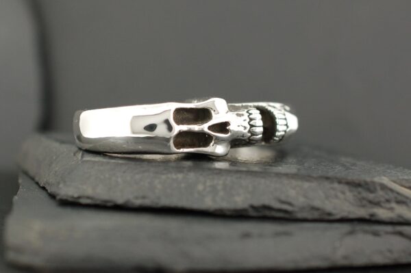Silver skull ring with detailed teeth design.