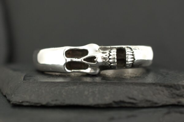 Close-up of a silver ring with a skull design.