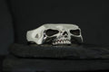 A silver ring shaped like a skull with detailed teeth and hollow eyes.