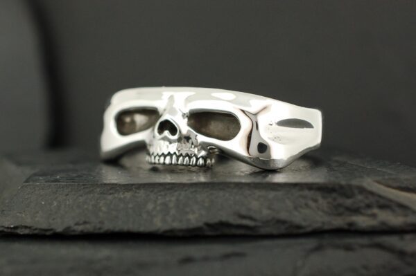 Silver ring featuring a detailed skull and bold design.