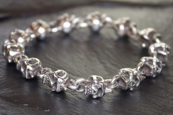 Close-up of a silver charm bracelet with detailed animal-shaped charms.
