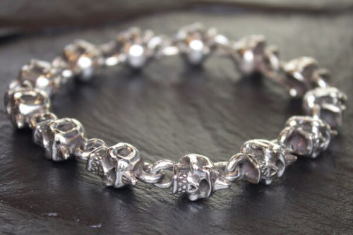 Close-up of a silver charm bracelet with detailed animal-shaped charms.