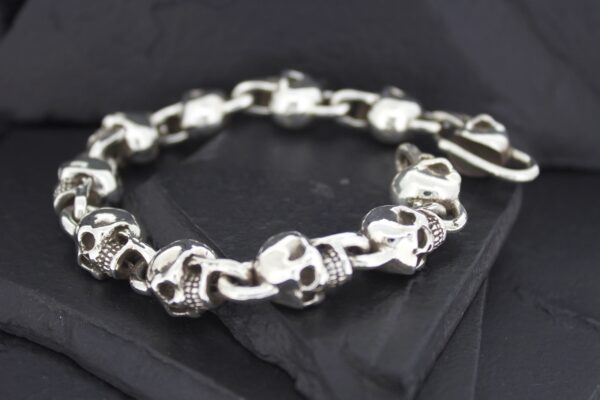 Silver skull and bone bracelet on black fabric.