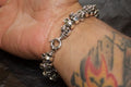 Silver skull bracelet on tattooed wrist.