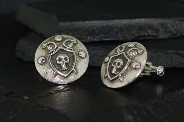 Antique silver cufflinks with skull and crescent moon designs.