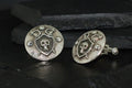 Antique silver cufflinks with skull and crescent moon designs.