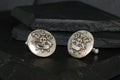 Vintage silver cufflinks with a detailed heraldic crest design.