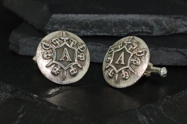 Pair of vintage silver cufflinks with intricate design and letter 'A'.