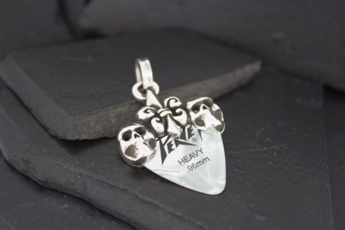 Silver pendant with skull designs and inscription.