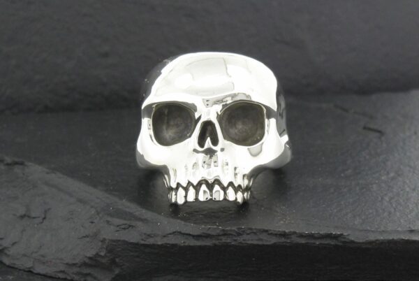 A polished silver skull ring with detailed features.