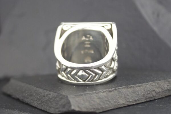 Intricately designed silver ring with geometric patterns.